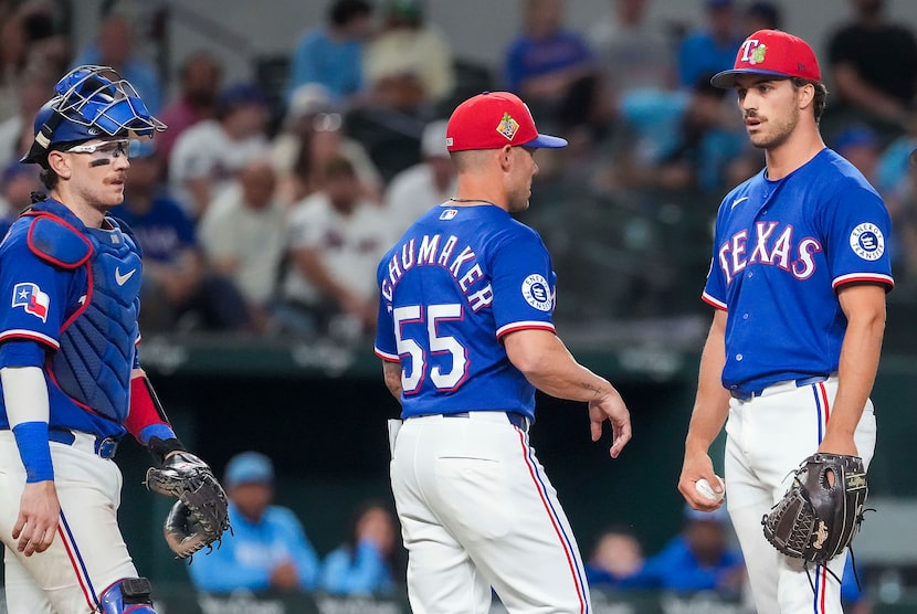 Texas Rangers pitcher Carter Baumler (right) reacts as manager Skip Schumaker makes a mound...