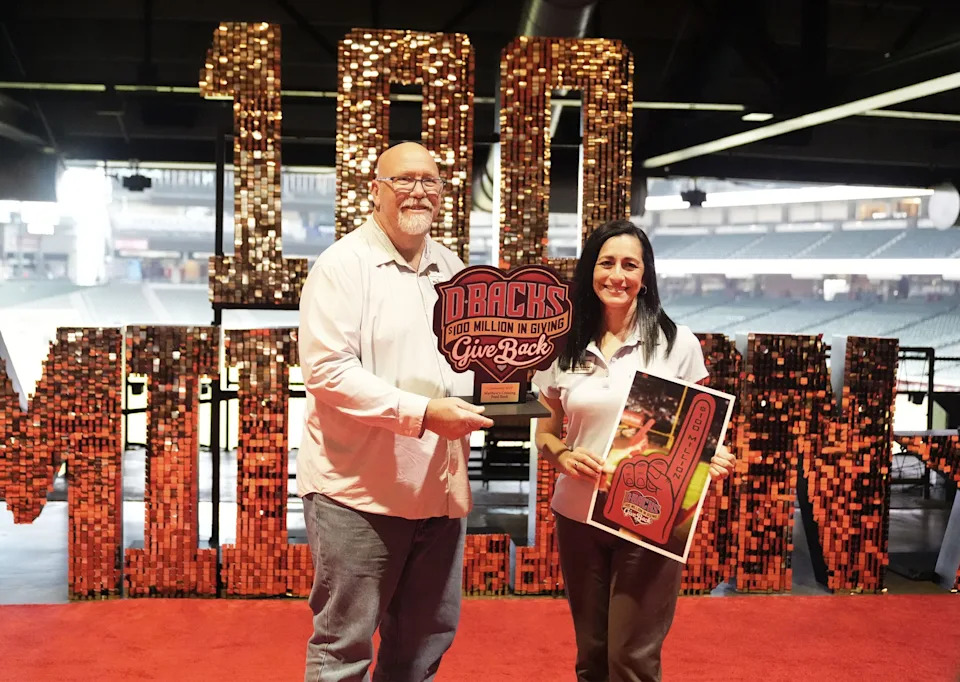 Mike Dipper and Jennifer Francisco with Matthew's Crossing Food Bank celebrate the $100 million raised by the D-backs Give Back fund that benefits charities across Arizona during an event hosted by the Arizona Diamondbacks at Chase Field on March 9, 2026, in Phoenix.