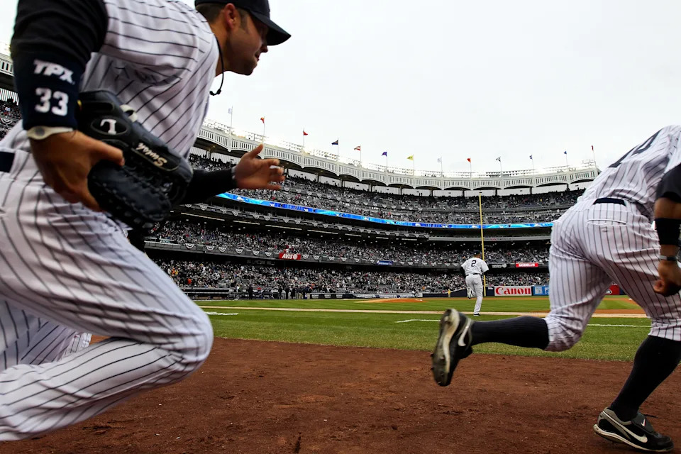Nick Swisher #33, Derek Jeter #2 and Curtis Granderson #14 of the New York Yankees take the field.