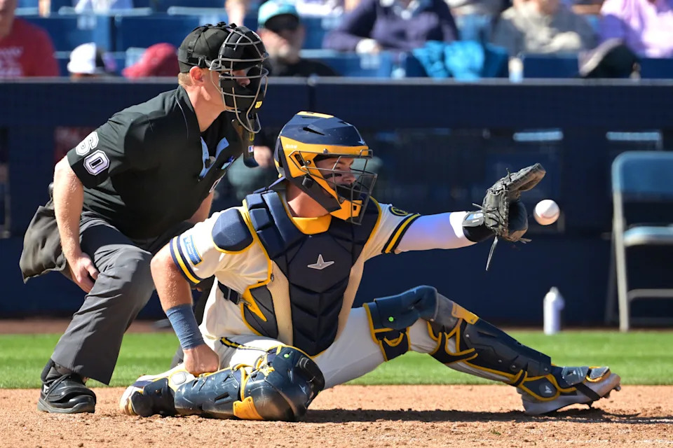 Feb 21, 2026; Phoenix, Arizona, USA; Umpire Brian Walsh (60) makes the call behind Milwaukee Brewers catcher Reese McGuire (33) against the Cleveland Guardians at American Family Fields of Phoenix. Mandatory Credit: Jayne Kamin-Oncea-Imagn Images
