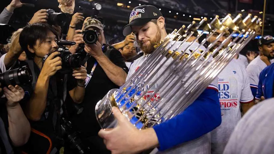 Texas Rangers pitcher Jordan Montgomery holds the World Series trophy.