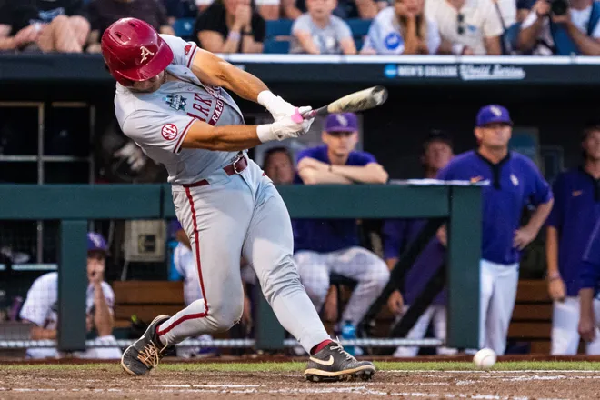Jun 18, 2025; Omaha, Neb, USA; Arkansas Razorbacks catcher Ryder Helfrick (27) hits a fielders choice that drives in two runs against the LSU Tigers during the eighth inning at Charles Schwab Field. Mandatory Credit: Dylan Widger-Imagn Images