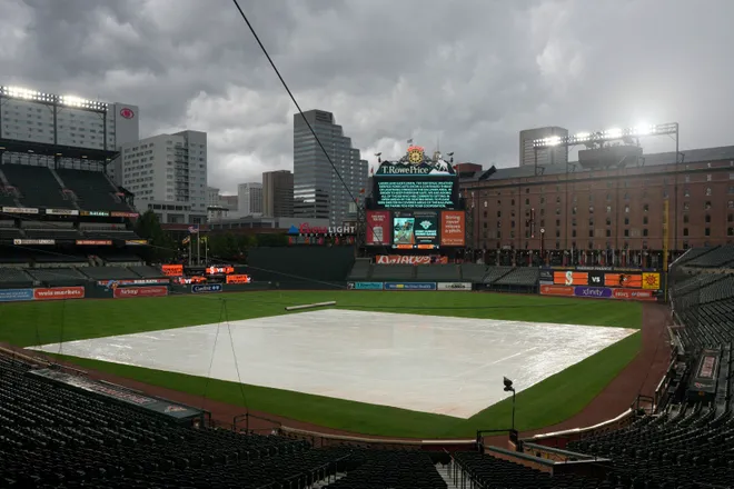 A tarp lies on the field as the start of the game between the Seattle Mariners and the Baltimore Orioles is delayed due to inclement weather at Oriole Park.