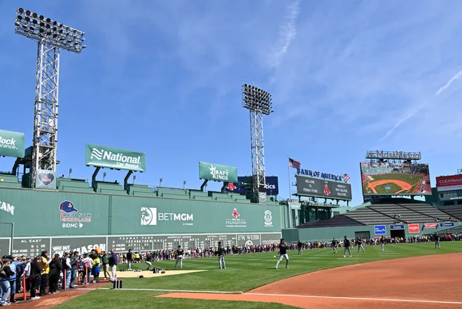 Fans line the field in front of the Green Monster as the Chicago White Sox warm up before a game at Fenway Park.