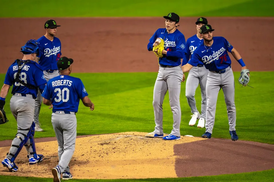 Los Angeles Dodgers pitcher Roki Sasaki (11) being relieved by manager Dave Roberts during an MLB spring training baseball game against the Kansas City Royals on March 17th, 2026 in Surprise, AZ.