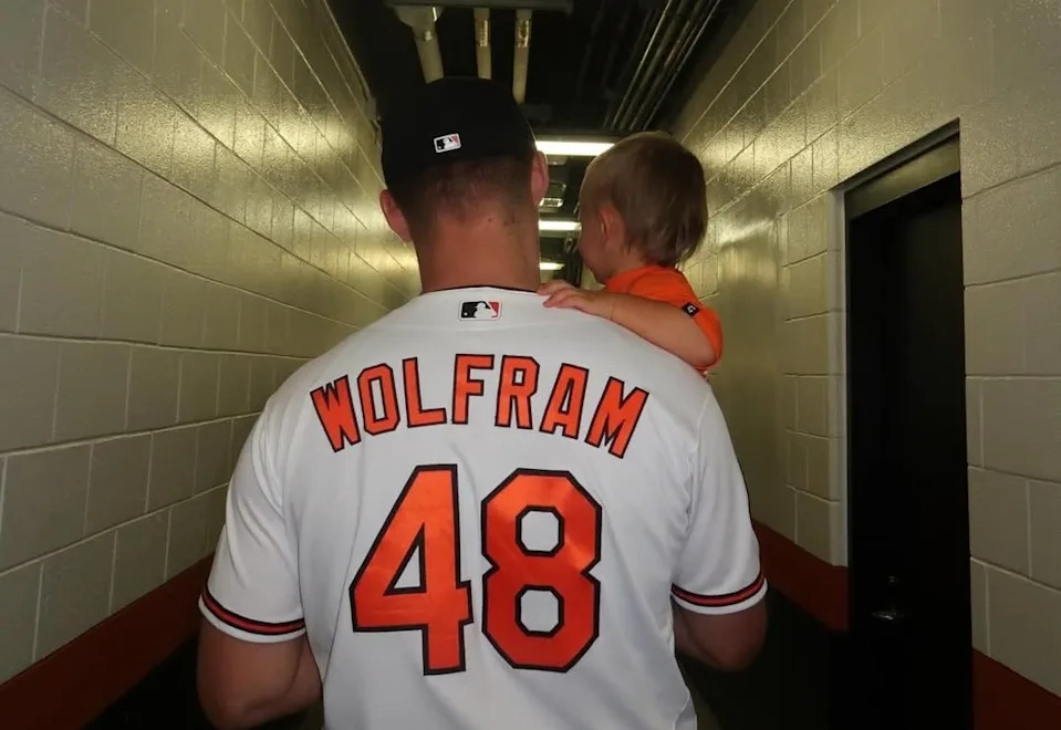 Baltimore pitcher Grant Wolfram walks with his son through the Ballpark at Camden Yards.