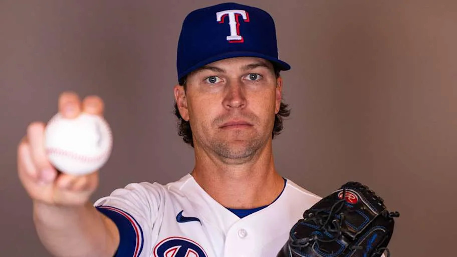 Texas Rangers pitcher Jacob deGrom holds a baseball while posing for a photo.