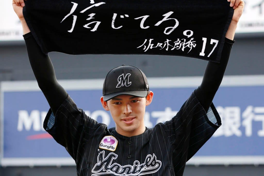 Chiba Lotte Marines pitcher Roki Sasaki poses with a towel after he made a record of a perfect game against the Orix Buffaloes in Chiba, near Tokyo Sunday, April 10, 2022. AP