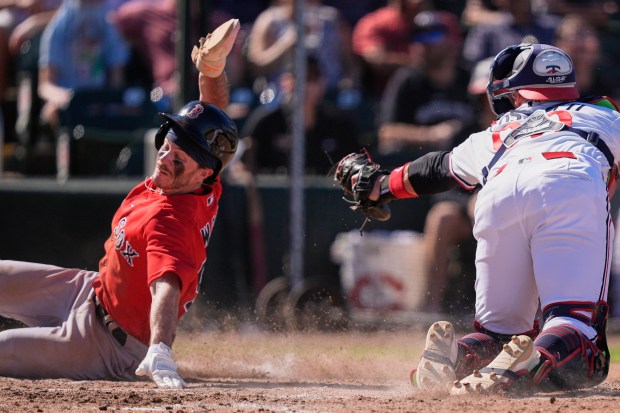 Boston Red Sox's Braiden Ward scores past Minnesota Twins catcher Andrew Cossetti in the seventh inning of a spring training game in Fort Myers, Fla., Saturday, Feb. 21, 2026. (AP Photo/Gerald Herbert)