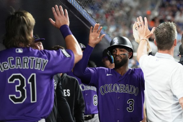 Colorado Rockies' Willi Castro (3) is congratulated after scoring on a single hit by Jordan Beck during the fourth inning of a baseball game against the Miami Marlins, Friday, March 27, 2026, in Miami. (AP Photo/Lynne Sladky)