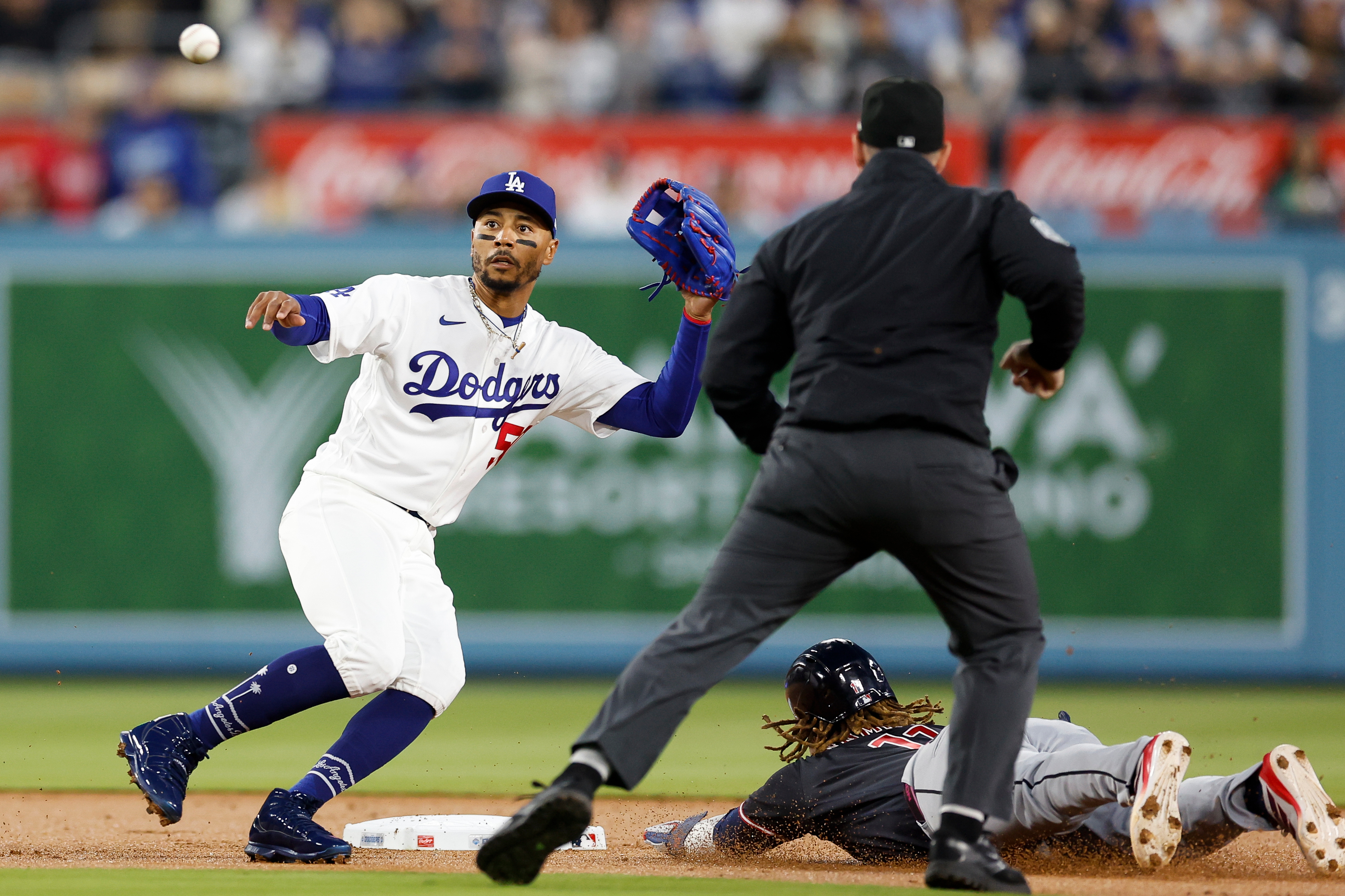 Dodgers shortstop Mookie Betts, left, prepares to catch the ball...