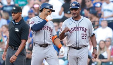 Houston Astros' Jeremy Peña, center, celebrates with first base coach Dave Clark (23) after hitting a single during the second inning of a baseball game against the Seattle Mariners, Friday, July 19, 2024, in Seattle. (AP Photo/Jason Redmond)