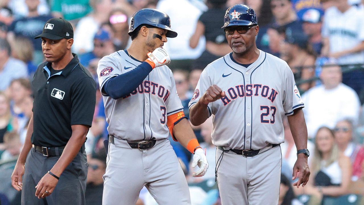 Houston Astros' Jeremy Peña, center, celebrates with first base coach Dave Clark (23) after hitting a single during the second inning of a baseball game against the Seattle Mariners, Friday, July 19, 2024, in Seattle. (AP Photo/Jason Redmond)