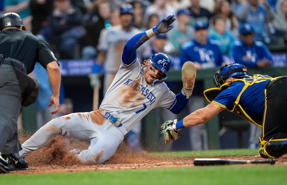Kansas City Royals' Bobby Witt Jr. (7) avoids the tag of Seattle Mariners catcher Cal Raleigh...