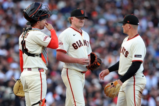 San Francisco Giants pitcher Logan Webb (62) meets on the mound with San Francisco Giants catcher Patrick Bailey (14) and San Francisco Giants' Matt Chapman (26) after the New York Yankees scored in the second inning of their opening night MLB game at Oracle Park in San Francisco, Calif., on Wednesday, March 25, 2026. (Ray Chavez/Bay Area News Group)
