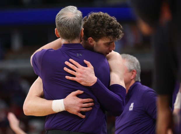 Northwestern forward Nick Martinelli hugs head coach Chris Collins, left, as he is taken out of the game in the final seconds of a 74-61 win over Indiana in the Big Ten Tournament at the United Center on March 11, 2026, in Chicago. (John J. Kim/Chicago Tribune)