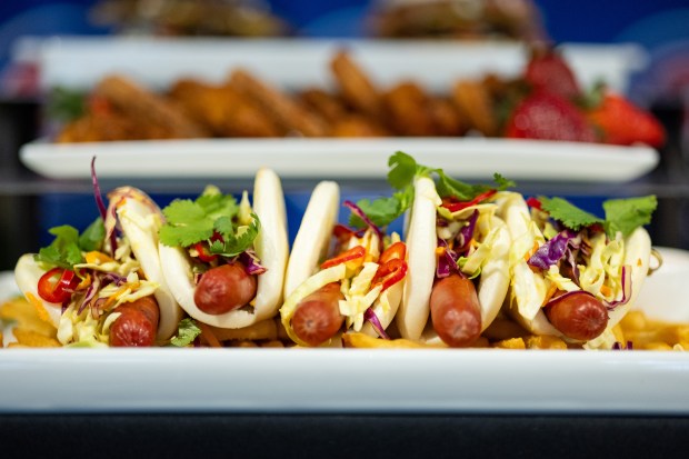 The Bao Wow Dog on display during the Taste of Wrigley Field event in the Home Plate Room on March 20, 2026. The dish includes a beef hot dog on a bao bun with mustard, tempura short peppers, Fresno peppers and sriracha aioli. (Josh Boland/Chicago Tribune)