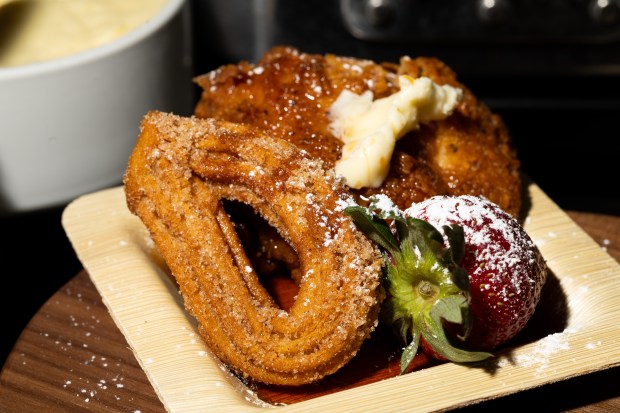 Chicken & Churros dish on display during the Taste of Wrigley Field event in the Home Plate Room on March 20, 2026. The dish includes fried chicken, churros, ancho syrup, and strawberries. (Josh Boland/Chicago Tribune)