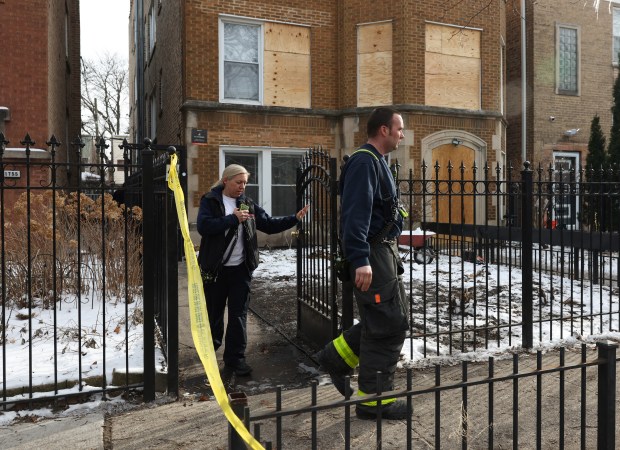 Firefighters leave after making a brief visit to the bottom floors of a residential building at 1757 W. North Shore Ave., March 17, 2026, in Chicago. Firefighter Michael Altman died Tuesday after suffering injuries while working to extinguish a fire at the building Monday. (John J. Kim/Chicago Tribune)