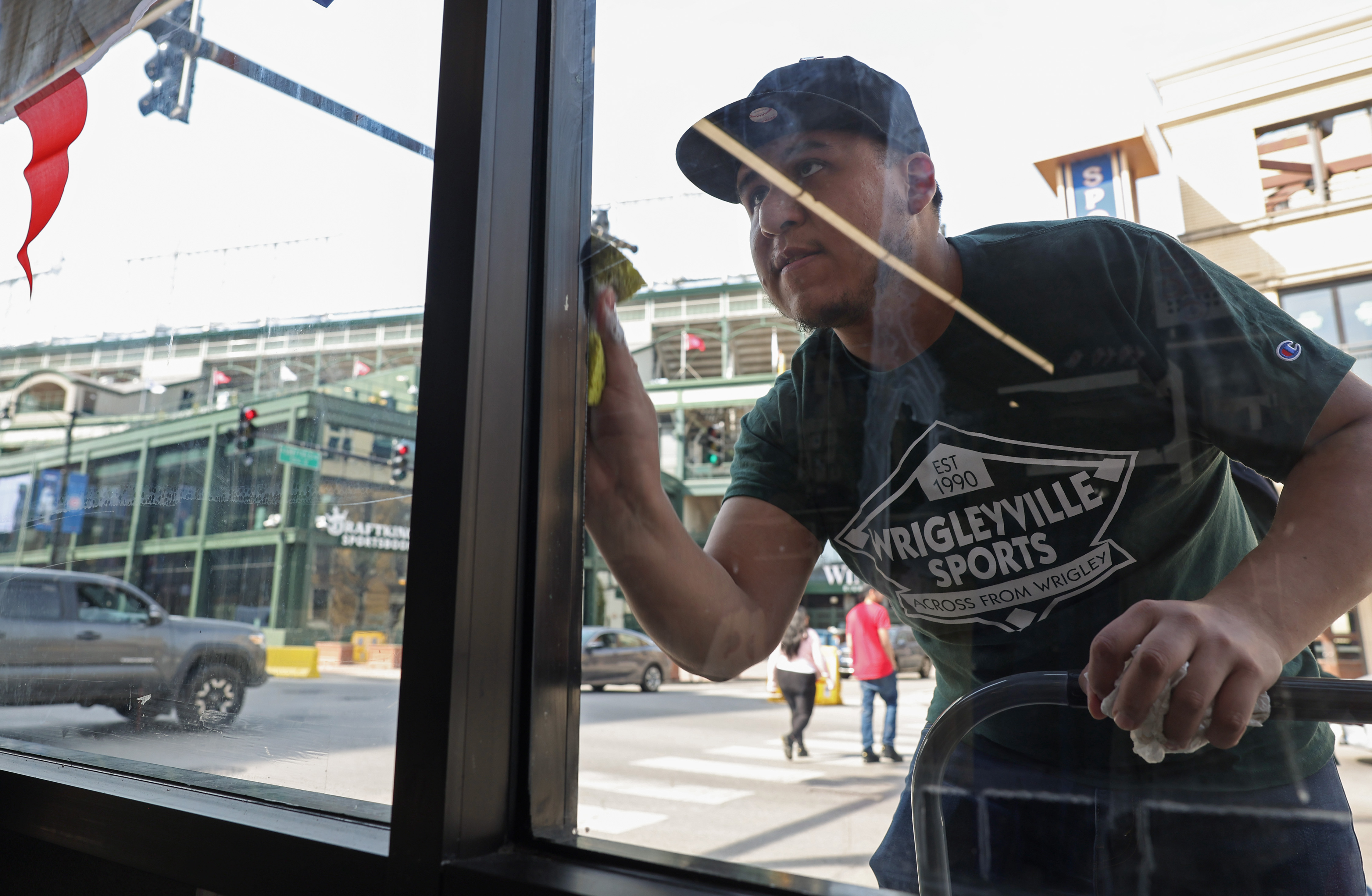 Felipe Martinez cleans windows at a sports apparel store across...