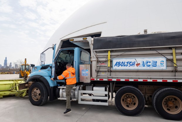 A driver gets out of the "Abolish ICE" snowplow that won the naming contest, on March 25, 2026, at a Streets and Sanitation facility in the West Town neighborhood. (Brian Cassella/Chicago Tribune)