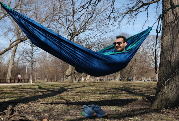 Michael Sousanieh rests in a hammock on an unseasonably warm day at Humboldt Park, March 21, 2026, in Chicago. (John J. Kim/Chicago Tribune)