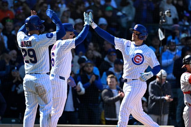 Cubs left fielder Ian Happ, right, high-fives Matt Shaw, center, and Michael Busch after hitting a three-run home run during the sixth inning against the Nationals on Saturday, March 28, 2026, at Wrigley Field. (Matt Marton/AP)