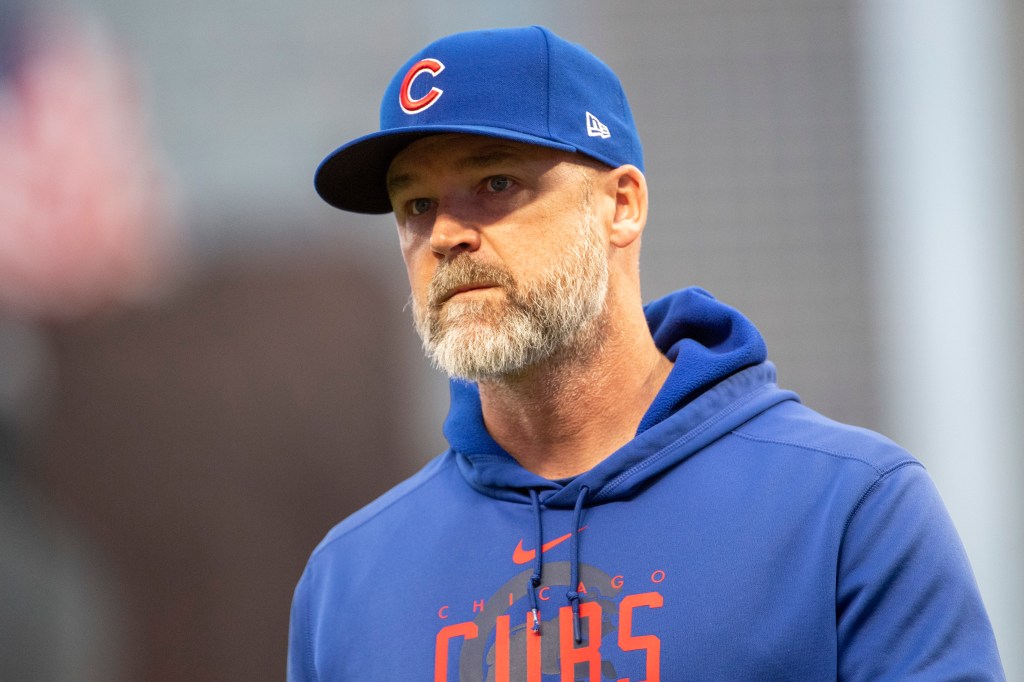 Craig Counsell wearing a blue Chicago Cubs cap and hoodie.