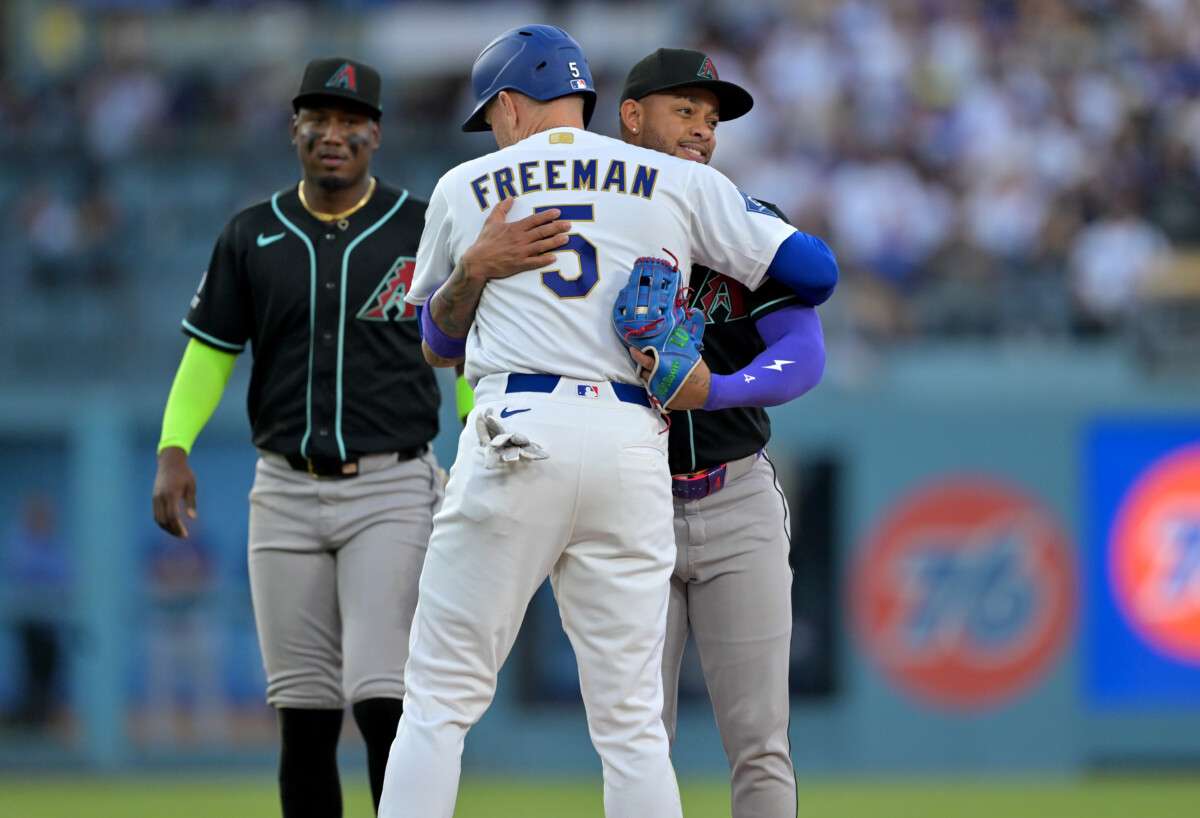 Mar 28, 2026; Los Angeles, California, USA; Arizona Diamondbacks second baseman Ketel Marte (4) hugs Los Angeles Dodgers first baseman Freddie Freeman (5) after tagging him out on a fielders choice during the second inning at Dodger Stadium. Mandatory Credit: Jayne Kamin-Oncea-Imagn Images