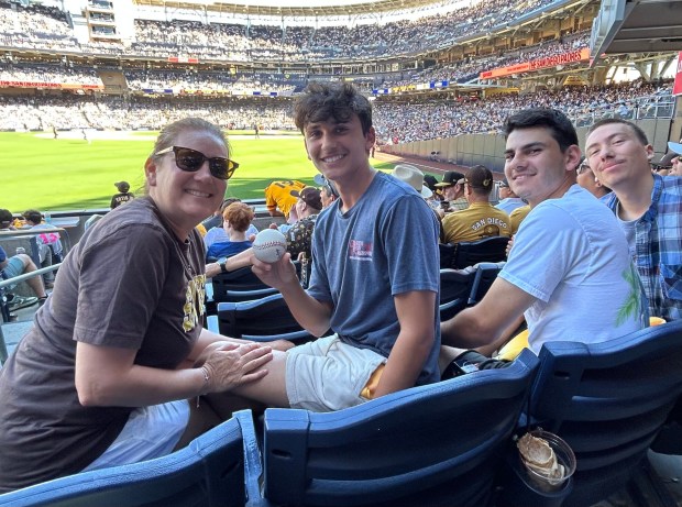 Gavin McVey holds the ball that Padres outfielder Ramon Laureano hit for a home run in the seventh inning.