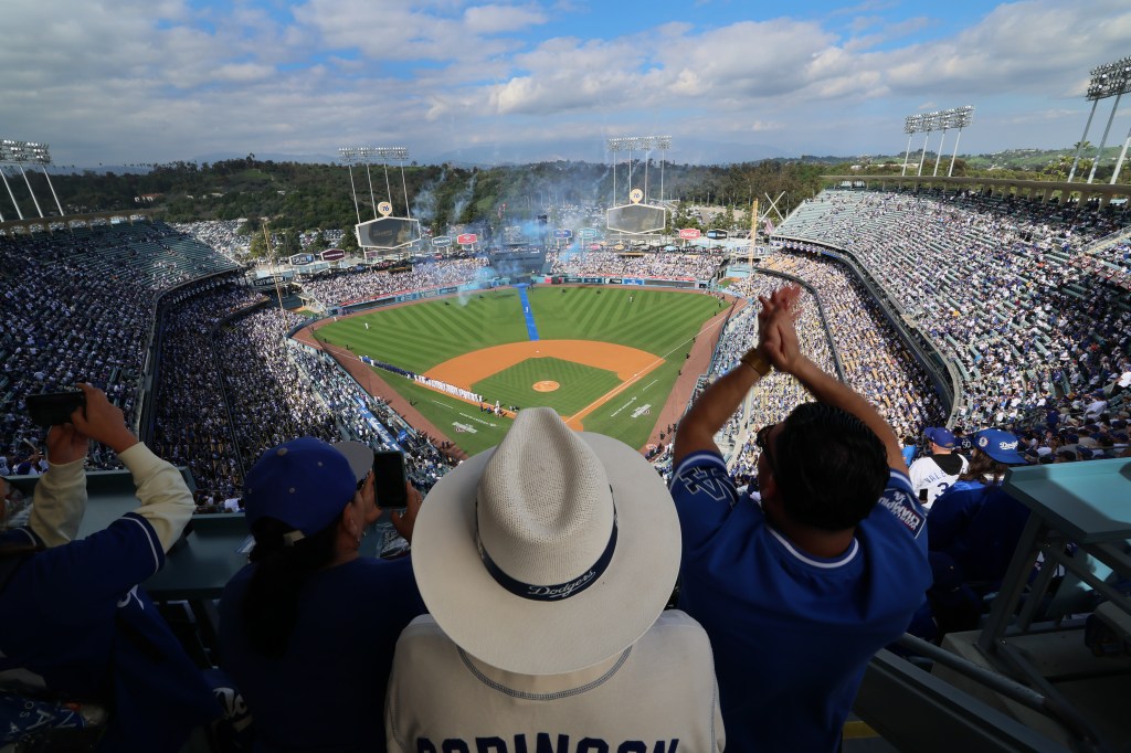 Baseball fans Lupe and Albert Rodriguez, and George Serrano, watching player introductions at Dodger Stadium.