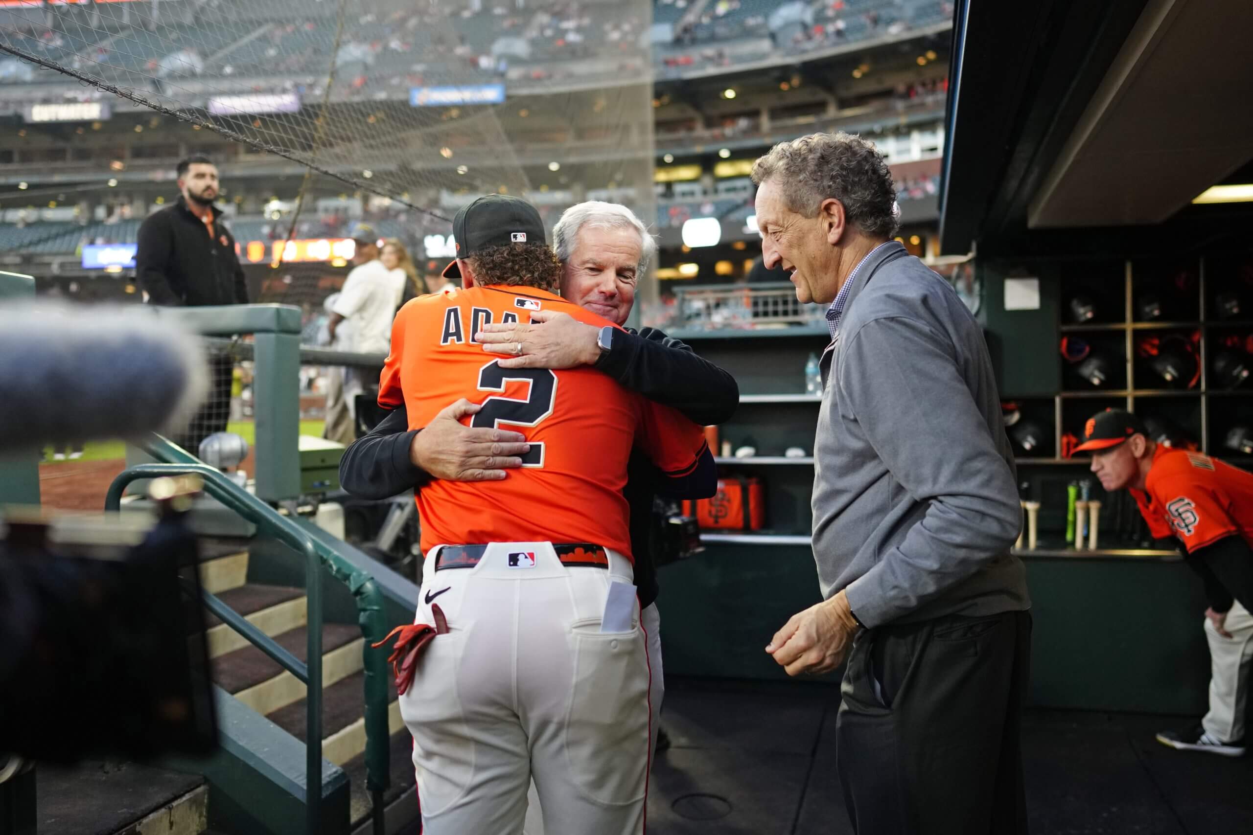 Willy Adames hugs Greg Johnson as Laryr Baer walks past.