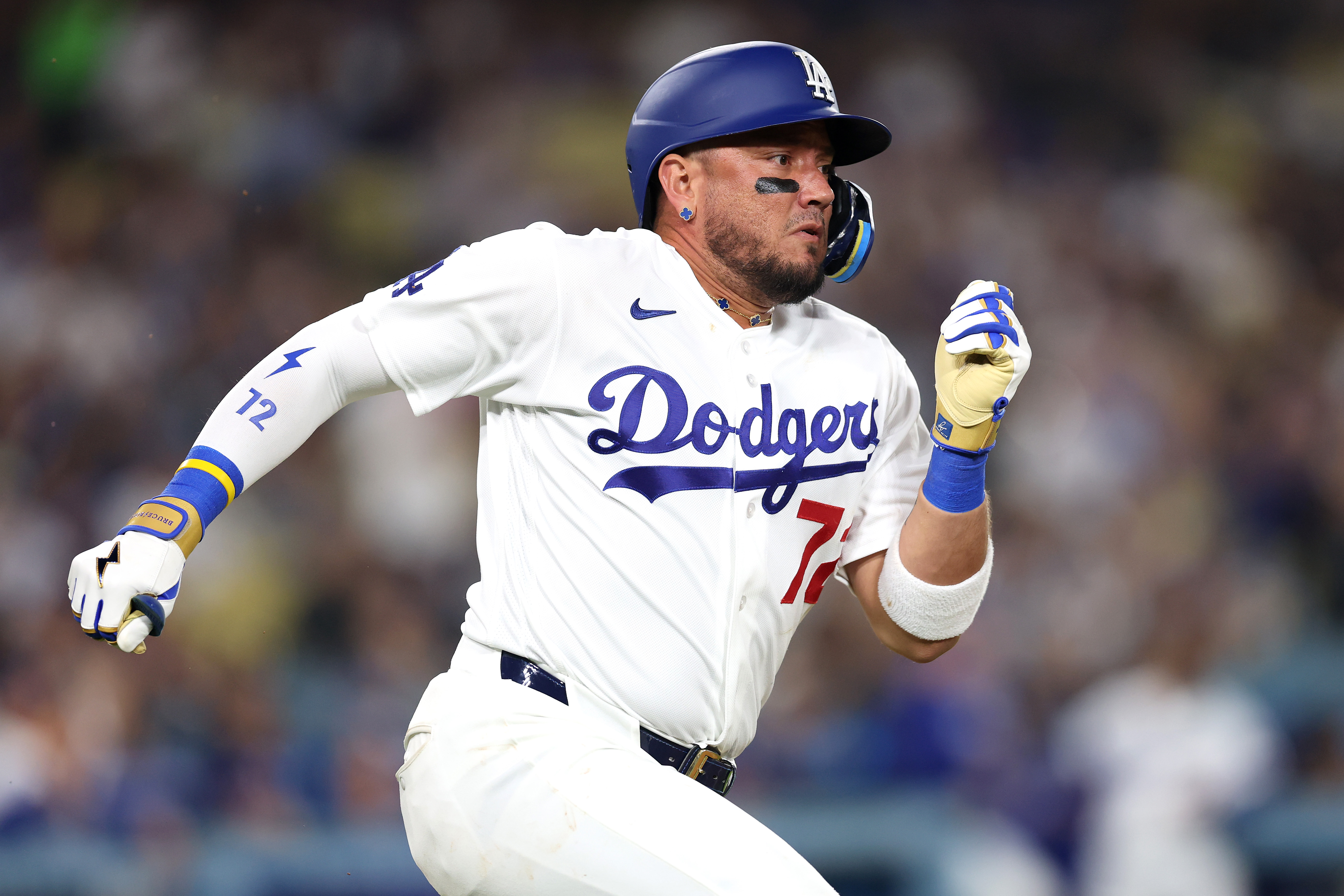 The Dodgers’ Miguel Rojas runs to first base during their...
