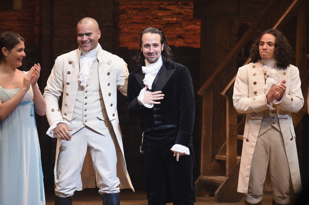 The cast of Hamilton stands on stage, bowing to the audience after a performance.