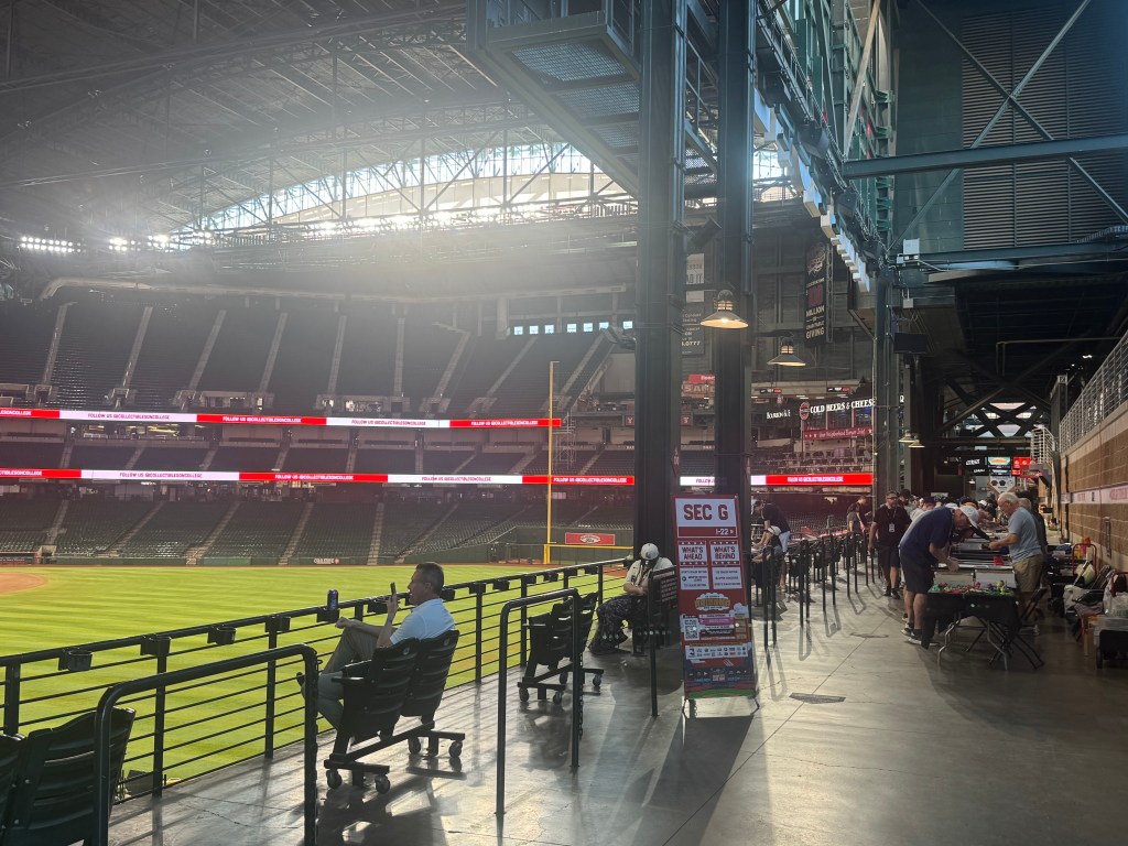 Fans are seated on the left while overlooking the grass at Chase Field as card dealers are making deals on the right.