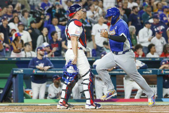Venezuela’s catcher Salvador Perez (13) scores after Maikel Garcia hits a sacrifice fly to center field as United States catcher Will Smith (16) looks towards the infield in the third inning of the final game of the 2026 World Baseball Classic against the United States at loanDepot park on Tuesday, March 17, 2026. 