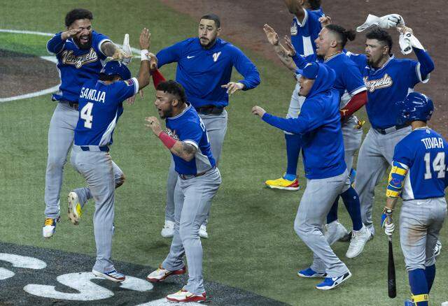 Venezuela outfielder Javier Sanoja (4) celebrates with his teammates after scoring a run against the United States in the ninth inning of their World Baseball Classic final game at loanDepot Park on Tuesday, March 17, 2026, in Miami, Fla.