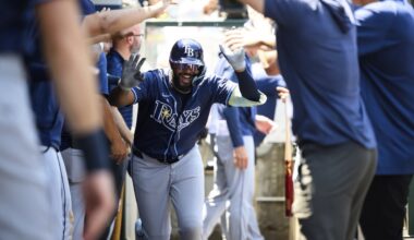 Tampa Bay Rays' Junior Caminero is greeted by teammates in the dugout after hitting a home run during the third inning of a baseball game against the Los Angeles Angels Wednesday, Aug. 6, 2025, in Anaheim, Calif. (AP Photo/William Liang)