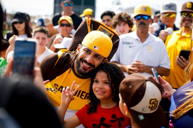 Fernando Tatis Jr. #23 of the San Diego Padres takes a photo with Emily Fuentes, 8, of Phoenix, during spring training workouts at the Peoria Sports Complex on Sunday, Feb. 15, 2026 in Peoria, Ariz.(Meg McLaughlin / The San Diego Union-Tribune)