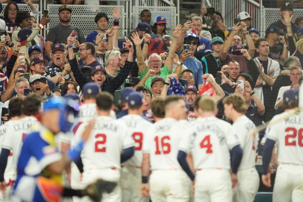 Fans react after United States Bryce Harper scores on a two-run home run during the eighth inning in the championship game of the World Baseball Classic against Venezuela, Tuesday, March 17, 2026, in Miami. (AP Photo/Rebecca Blackwell)