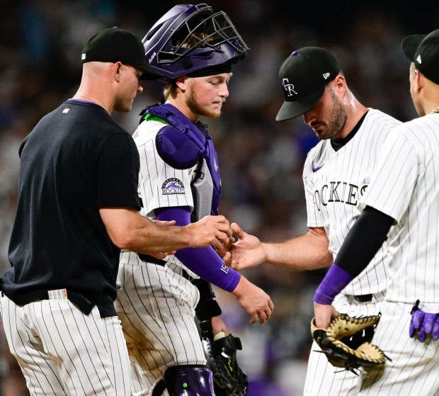 Colorado Rockies pitcher Tyler Kinley (40) hands the ball over to Colorado Rockies interim manager Warren Schaeffer (34), after giving up three runs in the 8th inning against the San Francisco Giants at Coors Field in Denver, on Wednesday, June 11, 2025. Colorado Rockies catcher Hunter Goodman (15) on the mound. (Photo by Andy Cross/The Denver Post)