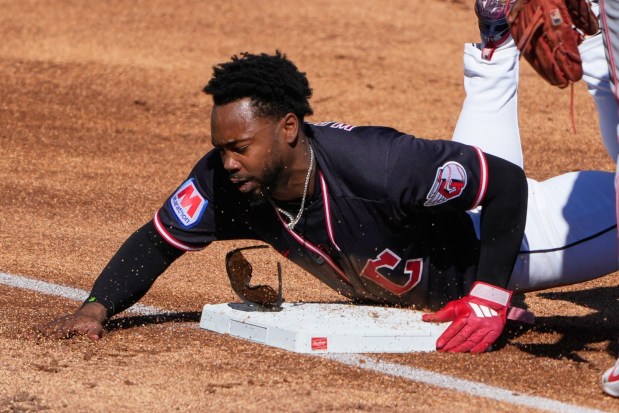 The Guardians' Kahlil Watson is safe at third after a wild throw during the fifth inning game against the Reds on Feb. 21 in Goodyear, Ariz. (Chris Carlson - The Associated Press)
