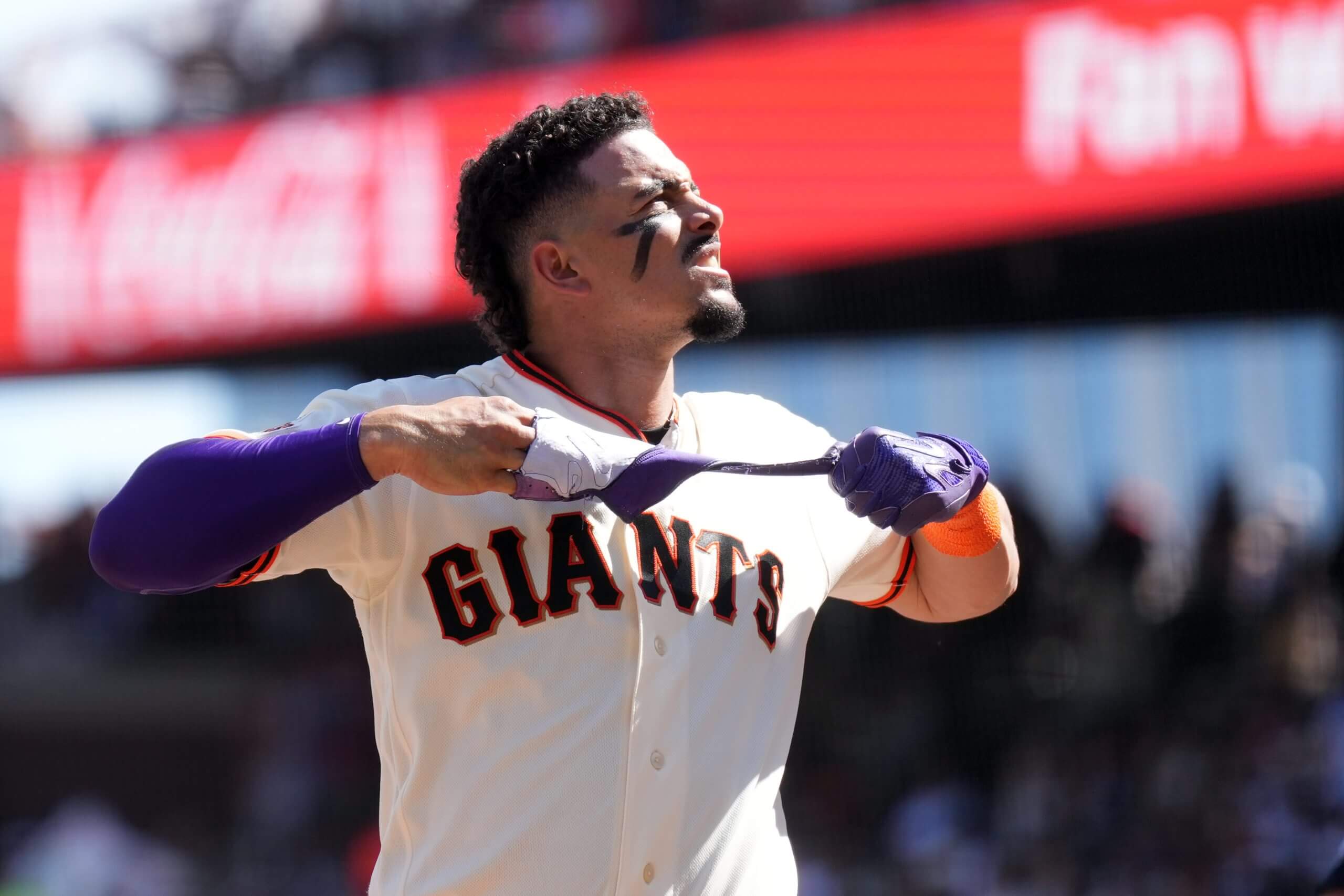 Willy Adames pulls a batting glove off his right hand at Oracle Park.