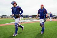 Texas Rangers catchers Danny Jansen (left) and Kyle Higashioka walk between drills during a...