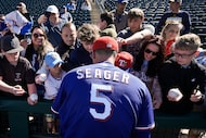 Texas Rangers shortstop Corey Seager signs autographs before a spring training game against...