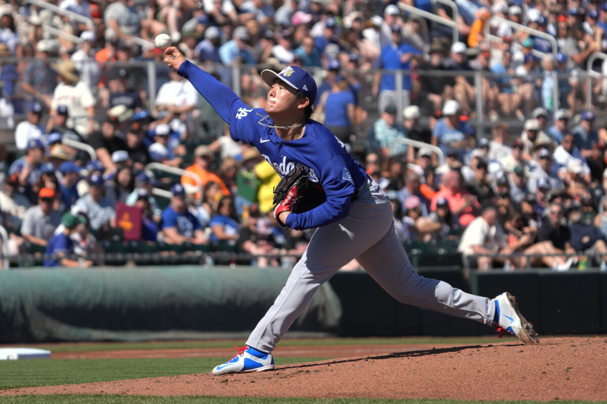 Los Angeles Dodgers pitcher Yoshinobu Yamamoto (18) throws against the San Francisco Giants in the first inning at Scottsdale Stadium.
