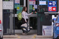 Primary voter Allie Davis carries her seven-week-old son Declan as a Dallas County Election...