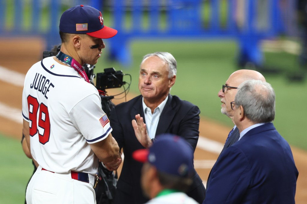 Baseball player Aaron Judge shaking hands with MLB commissioner Rob Manfred.