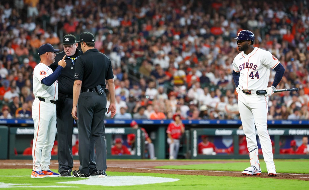 Houston Astros manager Joe Espada argues with home plate umpire Chris Conroy while designated hitter Yordan Alvarez looks on.