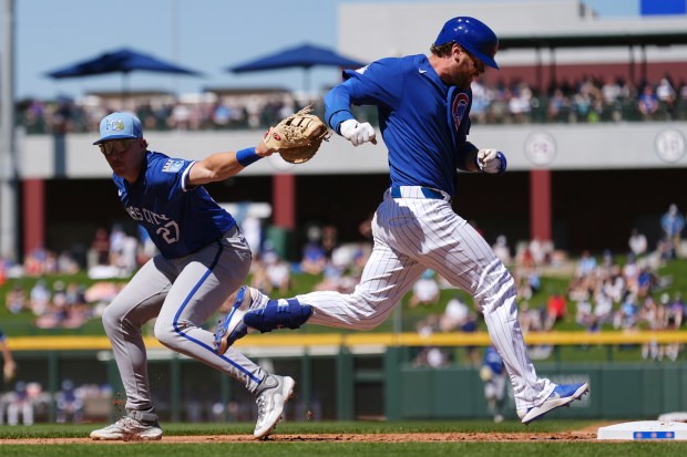 Chicago Cubs' Carson Kelly, right, beats out an infield single as Kansas City Royals first baseman Brett Squires (27) misses on the tag during the second inning of a spring training baseball game Wednesday, March 11, 2026, in Mesa, Ariz. (AP Photo/Ross D. Franklin)